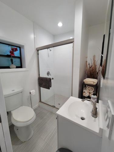 a white bathroom with a toilet and a sink at Guest suite near La Cienega Park Beverly Hills next to LACMA La Brea Tar Pits Peterson Museum and Academy Awards Museum in Los Angeles