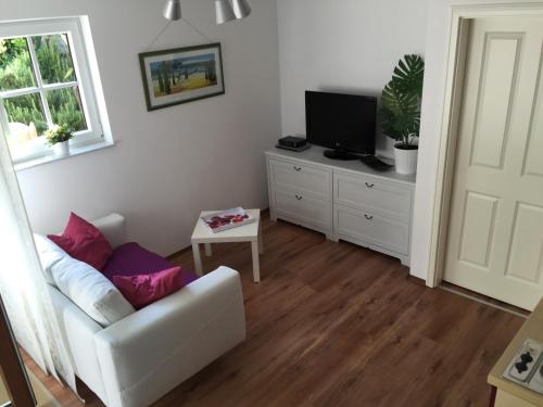 ein Wohnzimmer mit einem weißen Sofa und einem TV in der Unterkunft Villa Tuscia in Salzburg