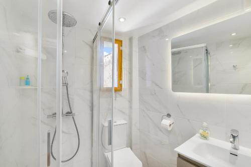 a white bathroom with a shower and a sink at Theodorou Stone House in Pano Lefkara