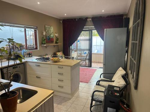 a kitchen with a sink and a refrigerator and a stove at Winelands Beach Cottage in Gordonʼs Bay