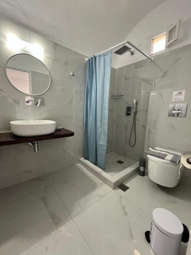a bathroom with a sink and a toilet and a shower at Stella Nomikou Apartments in Firostefani
