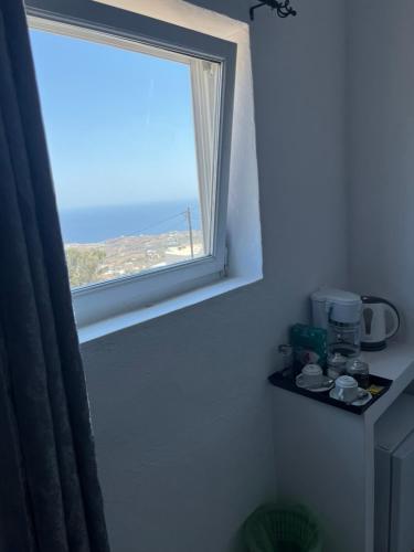 a window in a room with a view of the ocean at Stella Nomikou Apartments in Firostefani