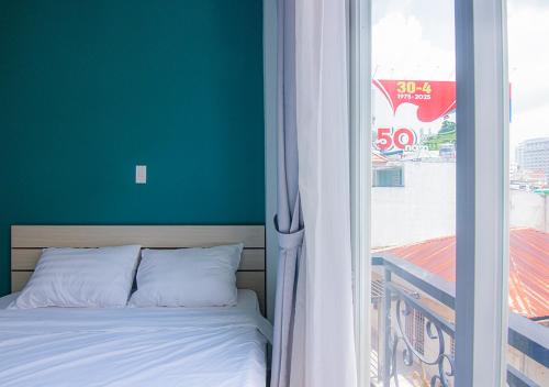 a bed sitting next to a window with a view at Lumina Home in Ho Chi Minh City