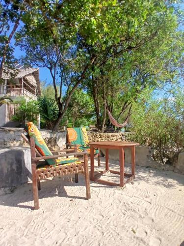 two chairs and a table on the beach at AFYA Village at the sea in Michamvi