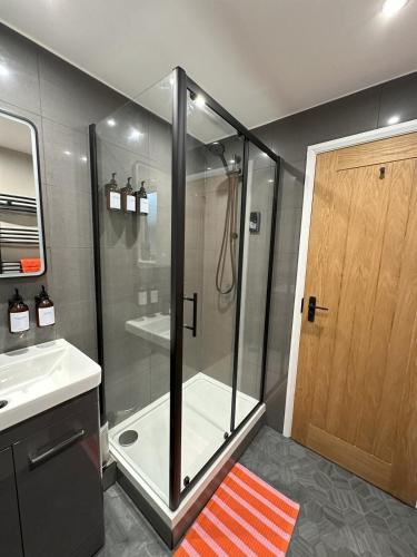a shower with a glass door in a bathroom at Short Walk to CoOp Live and Etihad Stadium in Manchester