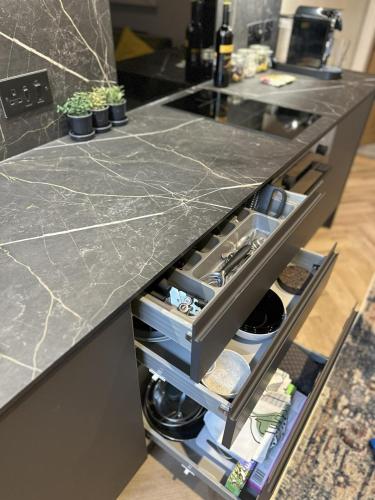 a kitchen with a black counter top with an open drawer at Short Walk to CoOp Live and Etihad Stadium in Manchester