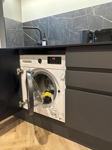a washing machine in a kitchen under a counter at Short Walk to CoOp Live and Etihad Stadium in Manchester