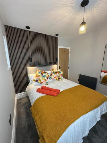 a bedroom with a large bed with a yellow blanket on it at Short Walk to CoOp Live and Etihad Stadium in Manchester