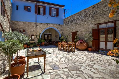 a patio with a table and chairs and a building at Theodorou Stone House in Pano Lefkara
