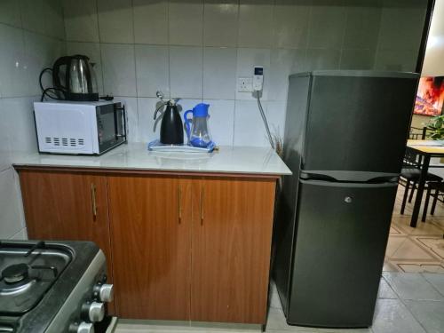 a kitchen with a refrigerator and a microwave at Nelimah Hosts in Machakos