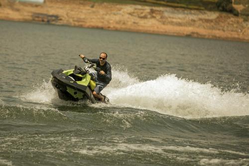 a man riding a jet ski in the water at La Pausa Hotelbistro in Guatapé