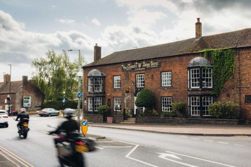 two people riding motorcycles in front of a brick building at Gaskell Arms in Much Wenlock
