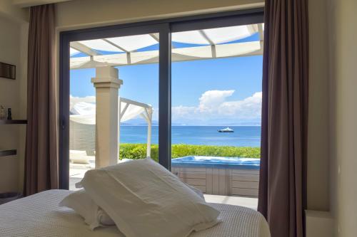 a bedroom with a bed and a view of the ocean at Palms and Spas Villas Retreat in Mesongi