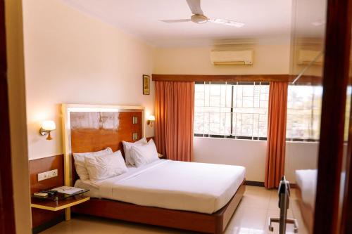 a bedroom with a large bed and a window at Bisque Magaji Orchid - Malleshwaram, Near Mantri Square Mall & Majestic in Bangalore