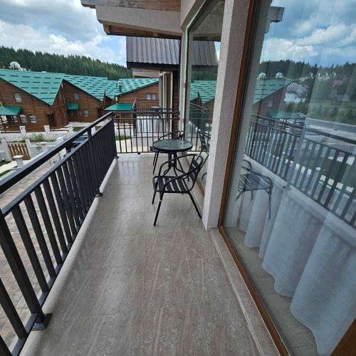 a balcony with a table and chairs on it at VM Apartments Zabljak in Razvršje