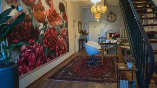a room with a staircase with a large painting of flowers at B&B 7 Rooms in Pisa
