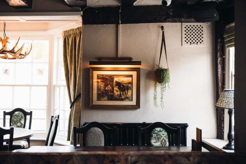 a dining room with a table and a picture on the wall at Gaskell Arms in Much Wenlock