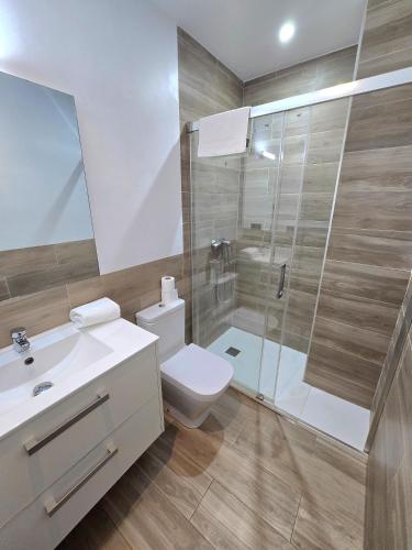 a bathroom with a white toilet and a shower at SM Apartments Station in Lleida