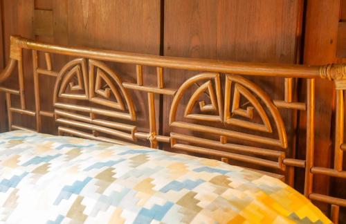 a wooden headboard of a bed in a room at Teak House Homestay II in Ban Thung Satong