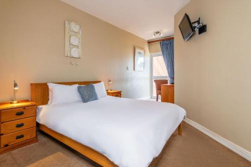 a bedroom with a large white bed and a window at Burning Shore Hotel in Langstrand