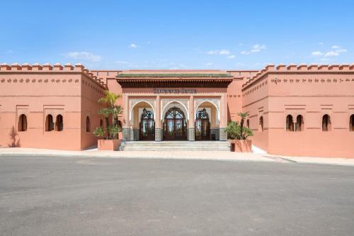 a large pink building with a street in front of it at Pickalbatros Hôtel Du Golf - Adults Friendly 16 Years Plus- All-Inclusive in Marrakech