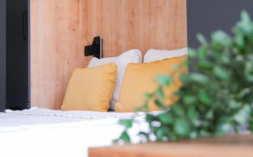 a bed with yellow pillows and a wooden headboard at Likya 202 in Demre