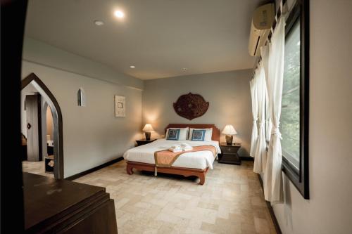 una camera da letto con un letto e una grande finestra di LannaOriental MaeRim a Mae Rim