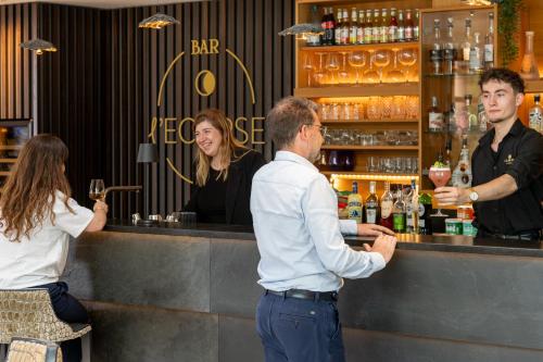 a group of people standing at a bar at Hotel L'Europe in Colmar