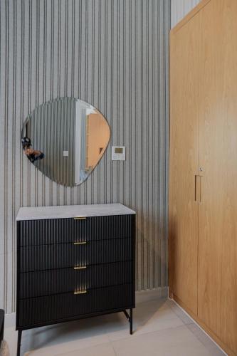 a mirror on a wall next to a dresser at 1BR Private Apartment - The Sultans Loft by Blue Cloud Holidays in Sharjah Intl