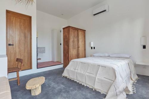 a bedroom with a bed and a wooden cabinet at Casa Ohma La Punta in Brisas de Zicatela