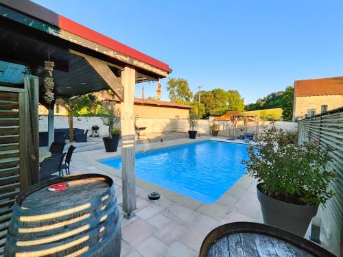 a swimming pool in a backyard with a pavilion at Au Vendangeoir Gîte de groupe piscine in Couvignon
