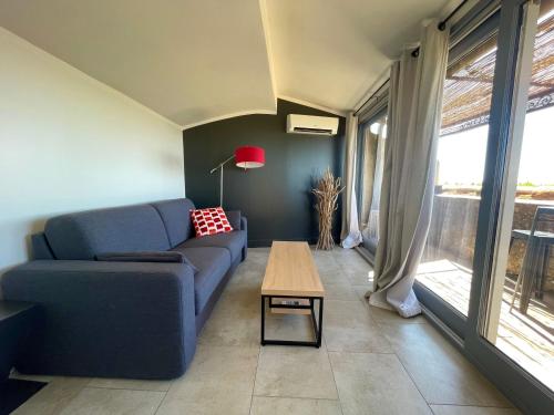 a living room with a blue couch and a table at Domaine de l'Enclos in Gordes