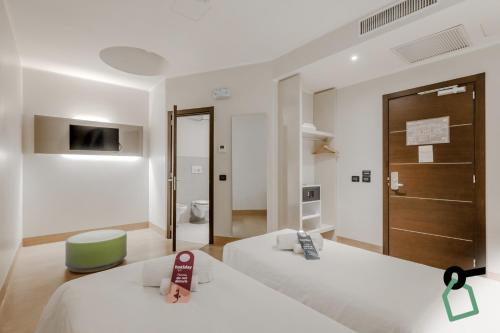 a hotel room with two beds and a bathroom at Hotiday Como Paoli in Como