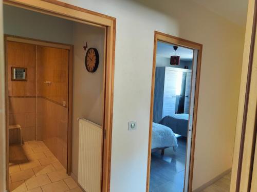 a hallway with a clock on the wall next to a door at Au Vendangeoir Gîte de groupe piscine in Couvignon