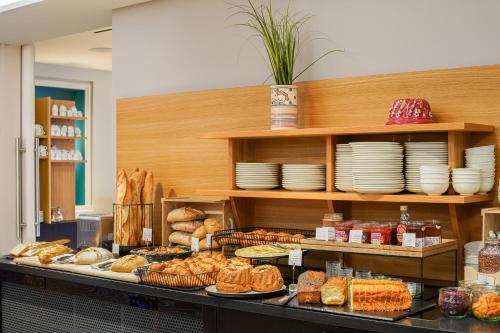 a bakery with bread and pastries on a counter at Hotel L'Europe in Colmar