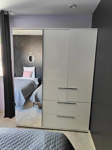 a large white dresser in a bedroom with a bed at Au Vendangeoir Gîte de groupe piscine in Couvignon