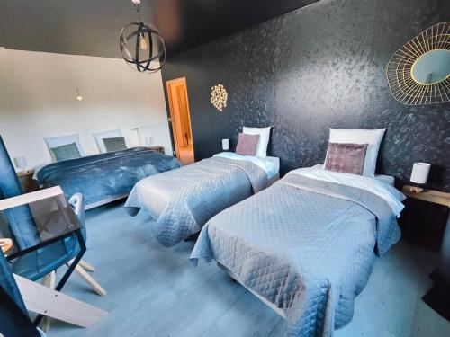 a bedroom with two beds and a wall at Au Vendangeoir Gîte de groupe piscine in Couvignon