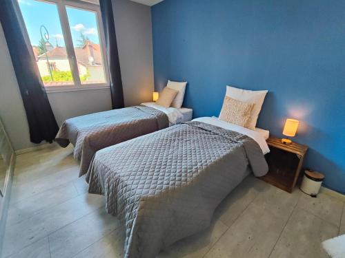 a bedroom with two beds and a window at Au Vendangeoir Gîte de groupe piscine in Couvignon