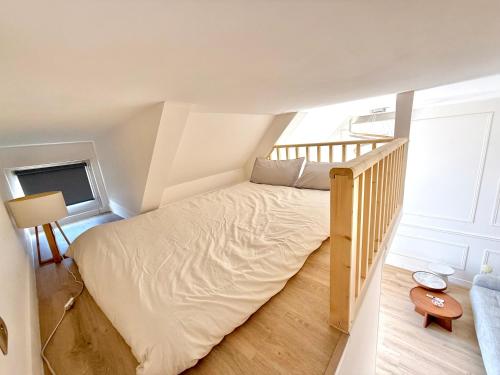 une petite chambre avec un lit et un escalier dans l'établissement Little LV2 Au cœur de l'Avenue des Champs-Elysées Arc de Triomphe, à Paris