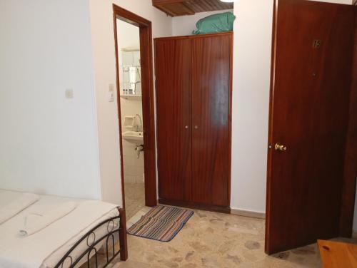 a bedroom with a bed and a wooden door at Hotel Mariboni in Samos
