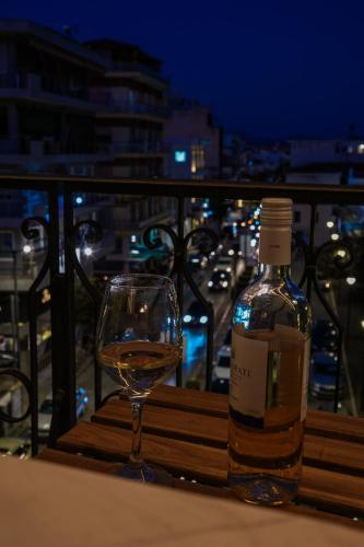 a bottle of wine and a glass on a table at Centre Ville Local Stays in Argos