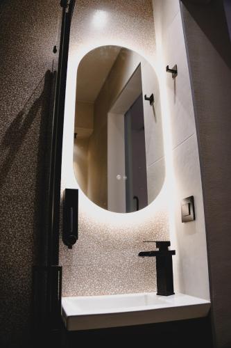 a bathroom with a mirror and a sink at Centre Ville Local Stays in Argos