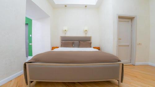 a bedroom with a large bed in a white room at Marita Hotel in Tbilisi City