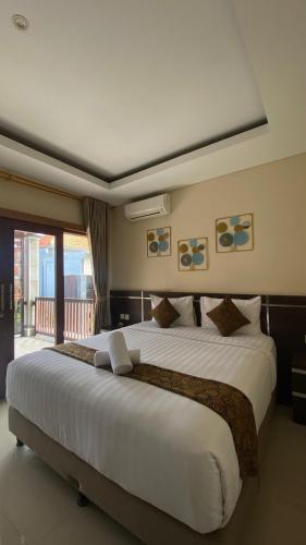 a large white bed in a hotel room at The Surya Kuta Villa in Kuta