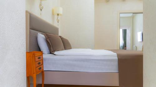 a bedroom with a bed and a dresser and a mirror at Marita Hotel in Tbilisi City