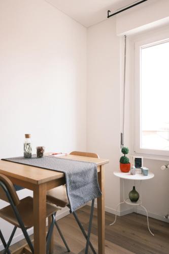 a table and a chair in a room with a window at Milano 71 in Milan