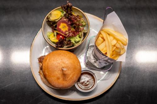 a plate of food with a sandwich and french fries at Hotel L'Europe in Colmar
