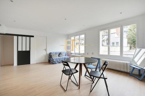 un salon avec une table et des chaises dans l'établissement Renew Spacious & Quiet Apartment, à Paris