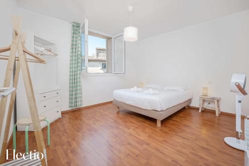 une chambre blanche avec un lit et une fenêtre dans l'établissement Maison Alena In the Heart of Lourmarin, à Lourmarin