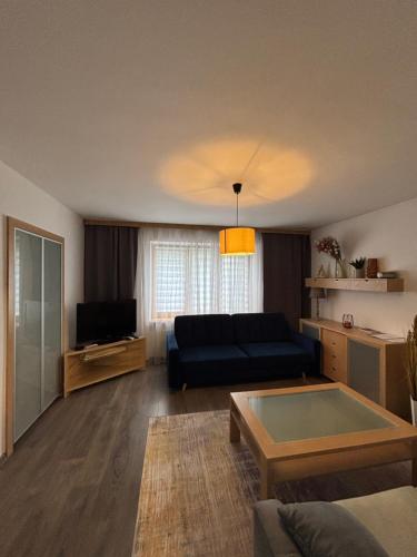 a living room with a couch and a tv at Krásny apartmám CENTRUM in Martin